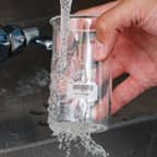 Temizlenen ve etiketi sökülen, Brady suda çözünebilir etikete sahip bir cam matara.