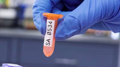 Brady kimyasal maddelere dayanıklı, düşük sıcaklığa uygun etikete sahip bir test tüpünü tutan laboratuvar teknisyeni.