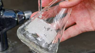 Temizlenen ve etiketi sökülen, Brady suda çözünebilir etikete sahip bir cam matara.