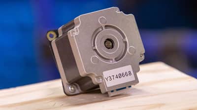 Küçük bir motor muhafazasının girintili çıkıntılı yüzeyine uygulanmış Brady ultra-kuvvetli yapışkanlı etiket.