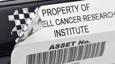 Etiketin söküldüğünü tanımlamak üzere sıyrıldığında metalik dama desenini gösteren, bir ekipman parçasına uygulanmış varlık etiketi.