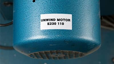 Endüstriyel bir motorun kavisli yüzeyine uygulanmış Brady ultra-kuvvetli polyester etiket.