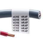 Gri bir kablonun üzerindeki Brady sarılabilir etiketin yakından görünümü. Etiket beyazdır ve kolay tanınması için tekrarlanan siyah metin içerir.