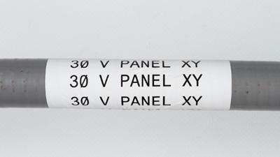 Kablo borusu üzerindeki beyaz bir etiket, okunuyor 