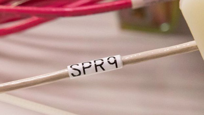 Tel kemeri içindeki beyaz bir tanımlama etiketine sahip ten rengi tel.