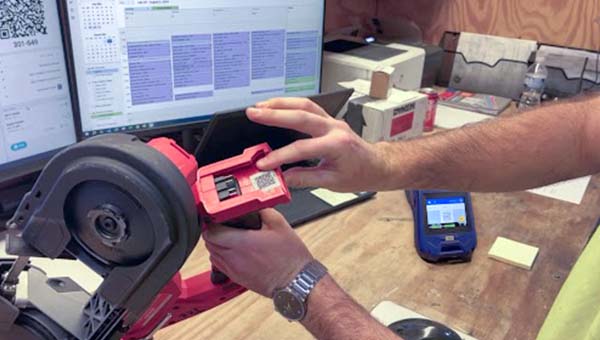 Bir kişi ekipman üzerindeki bir etiketi işaret ediyor.